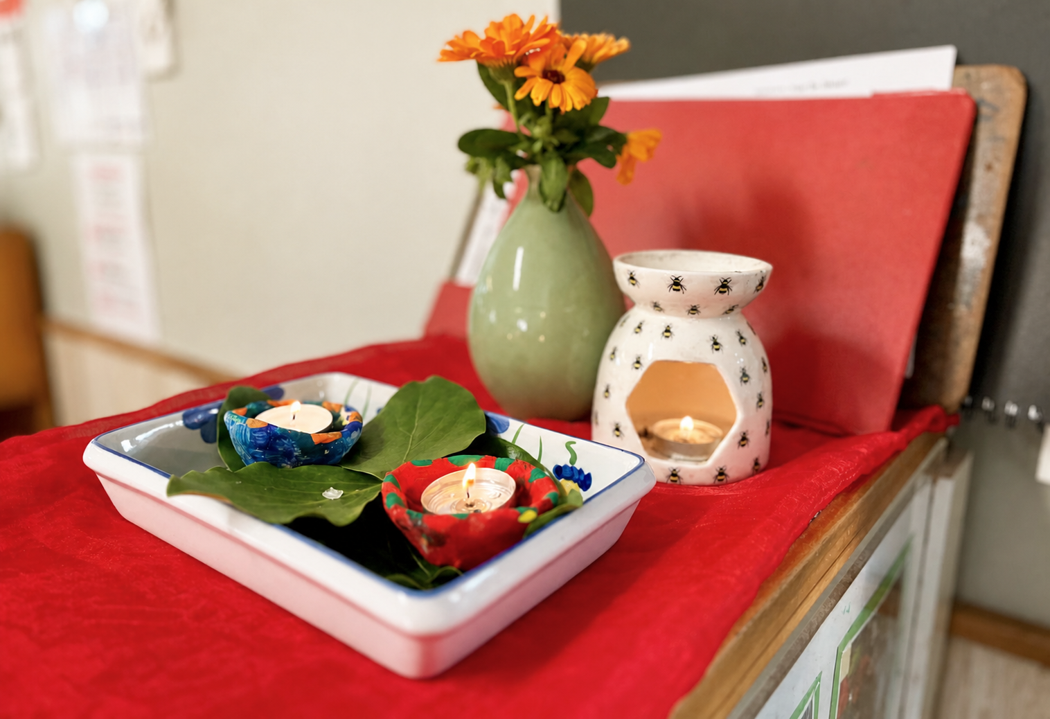 Diwali lamps and flowers on a red cloth