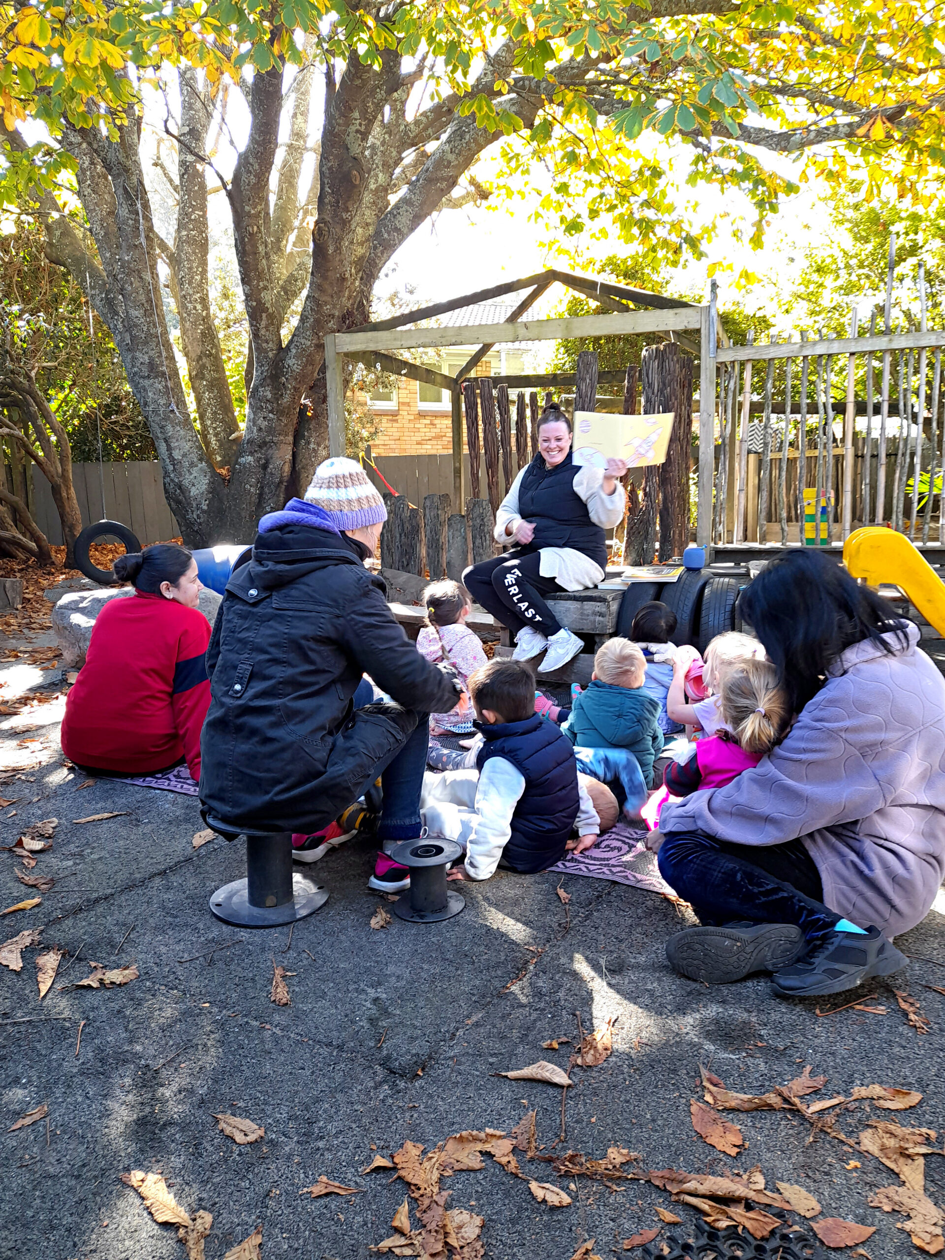 Teacher sharing a story with children outdoors