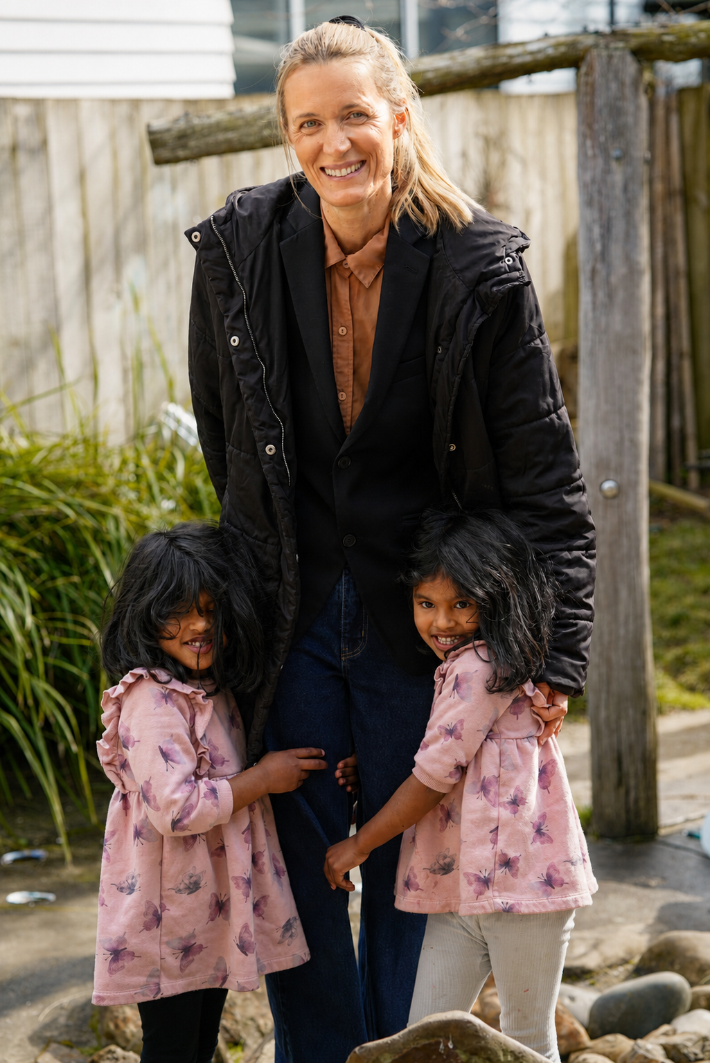 Teacher Hannah smiling with twins at the centre