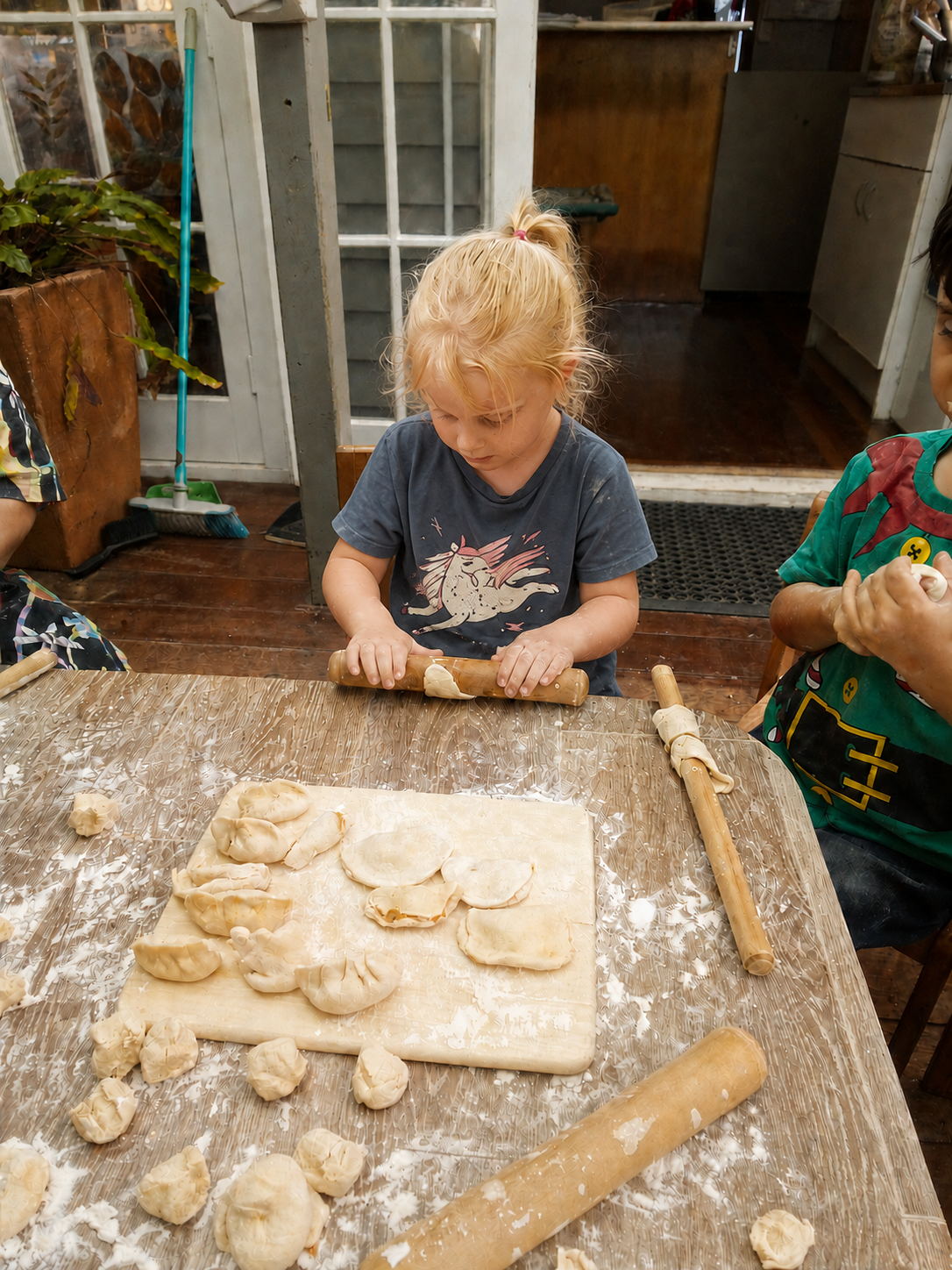 Child rolling dough to make dumplings